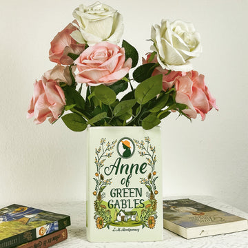Anne of Green Gables book vase with pink and white artificial roses, books on table