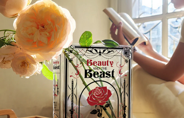 Beauty and the Beast book vase with roses, sunlight, person reading by window