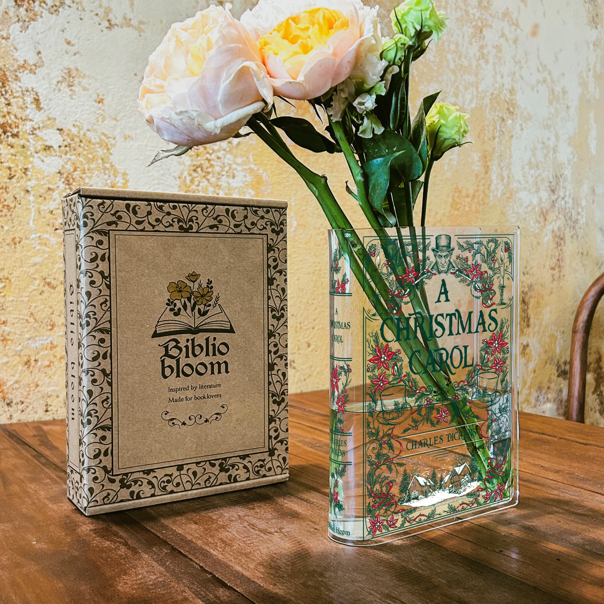 A Christmas Carol acrylic book vase with flowers and Biblio Bloom box on wooden table