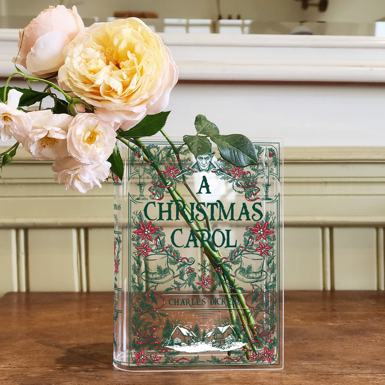 Acrylic book vase shaped like A Christmas Carol with flowers on a wooden table