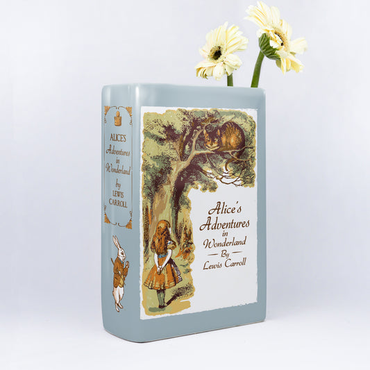 Alice's Adventures in Wonderland ceramic book vase with yellow flowers, illustrated cover