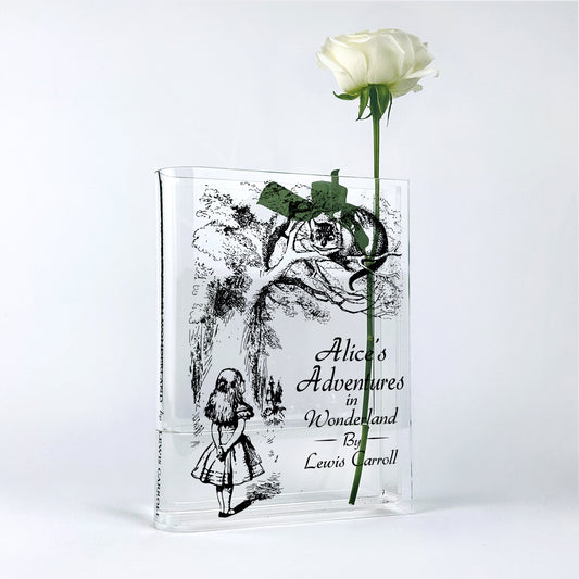 Alice's Adventures in Wonderland acrylic book vase with white rose, minimalist background