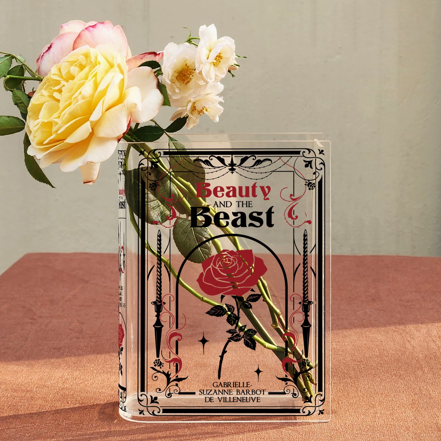 Beauty and the Beast acrylic book vase with roses on a pink table