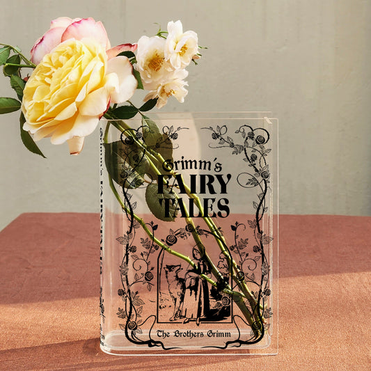 Grimm's Fairy Tales acrylic book vase with roses on a pink tablecloth
