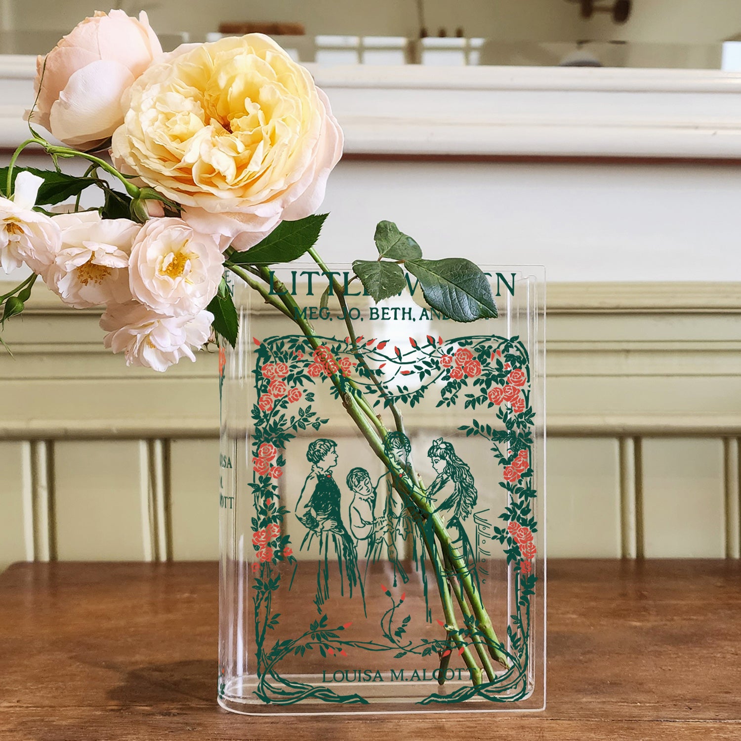 Acrylic Little Women book vase with peach roses on wooden table, vintage style decor