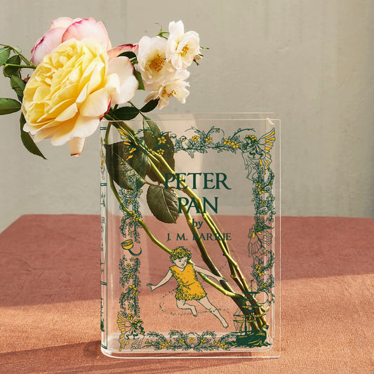 Peter Pan acrylic book vase with roses on a terracotta table in natural light