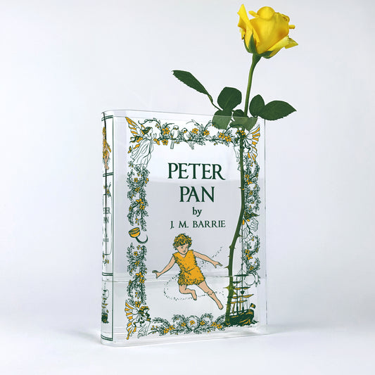 Acrylic Peter Pan book vase with yellow rose, floral border, and J.M. Barrie cover design.