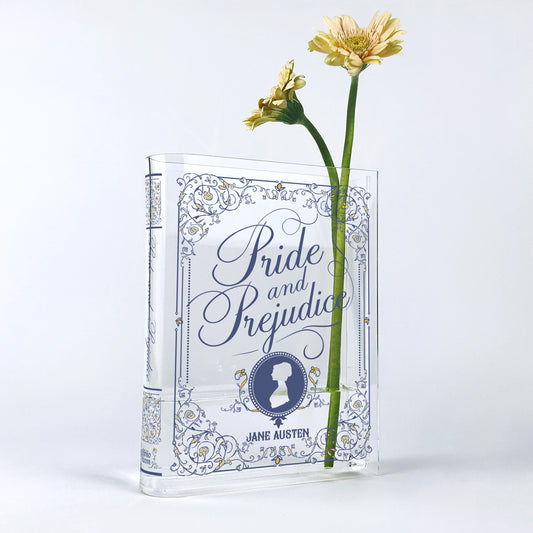 Acrylic book vase shaped like Pride and Prejudice with yellow flowers, white background