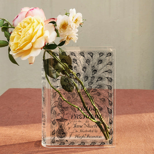 Pride and Prejudice acrylic book vase with floral design holding yellow and white roses