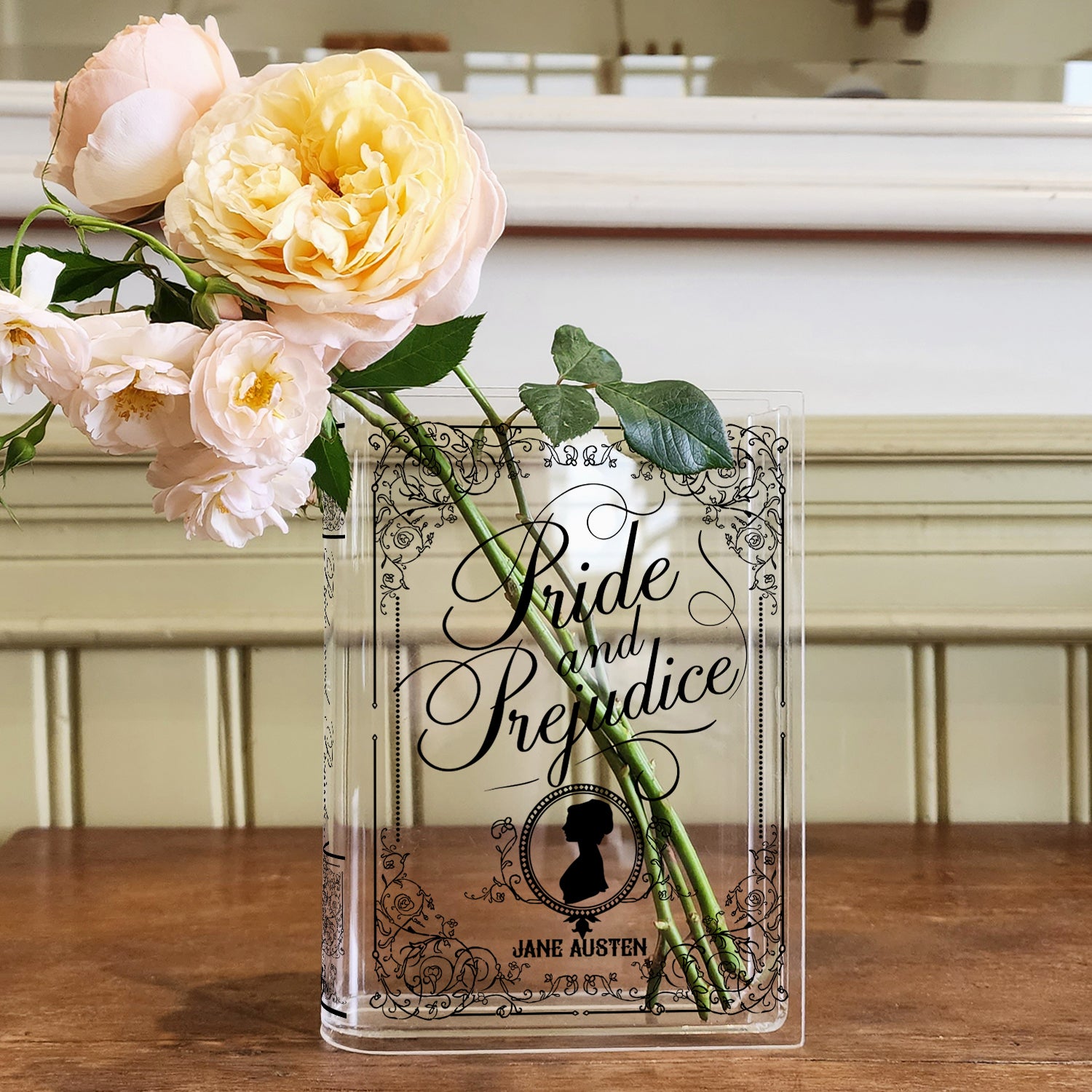 Acrylic Pride and Prejudice book vase with yellow roses on a wooden table