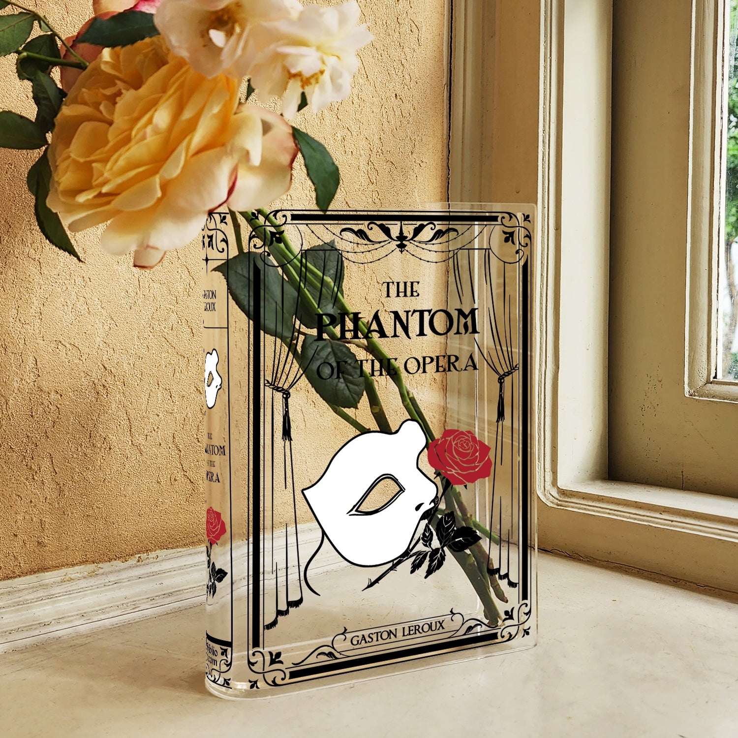 Phantom of the Opera acrylic book vase with rose and mask design on window sill