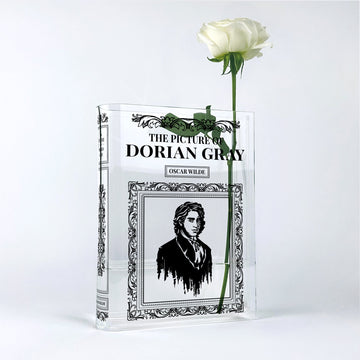 Acrylic book vase shaped like The Picture of Dorian Gray with a single white rose inside.