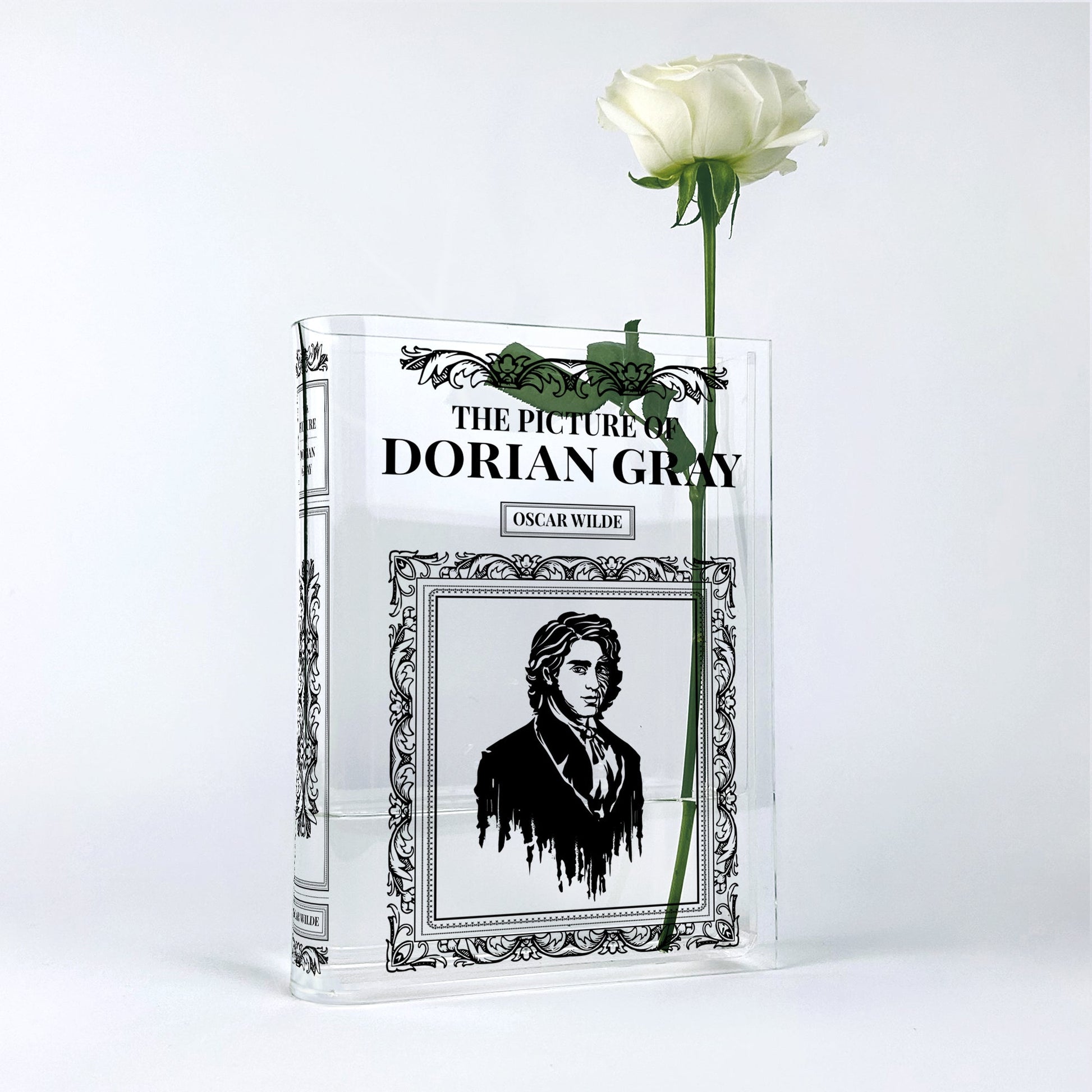 Acrylic book vase shaped like The Picture of Dorian Gray with a single white rose inside.