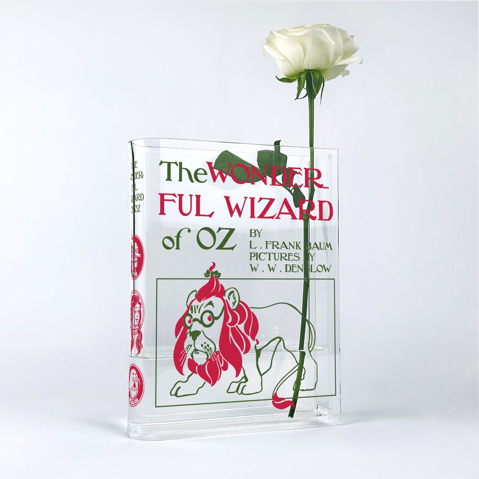 The Wonderful Wizard of Oz acrylic book vase with white rose against white background.