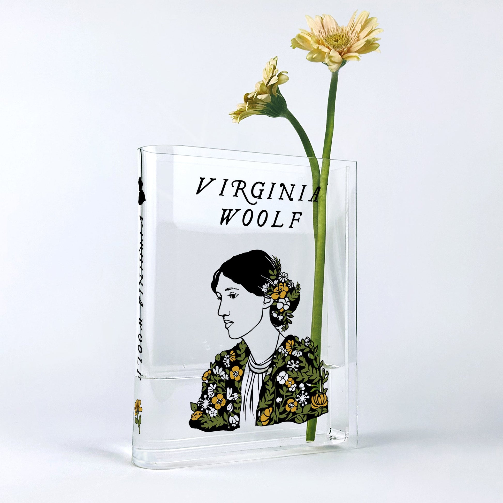 Virginia Woolf acrylic book vase with yellow gerbera daisies on white background