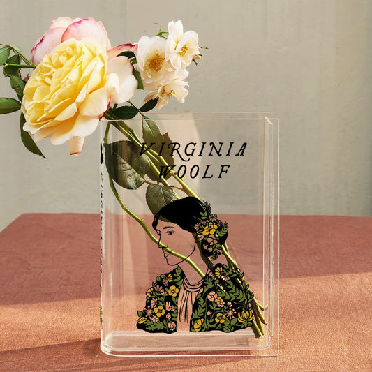 Virginia Woolf acrylic book vase with yellow and white flowers on a textured surface