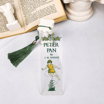 Peter Pan illustrated bookmark with green tassel on open book and white decorative props.
